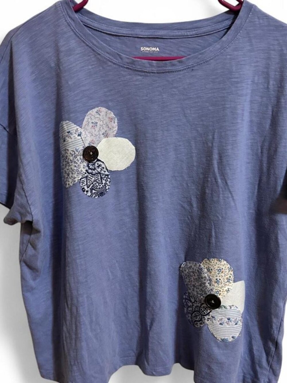 Blue cotton t-shirt with white floral appliqué featuring handsewn buttons